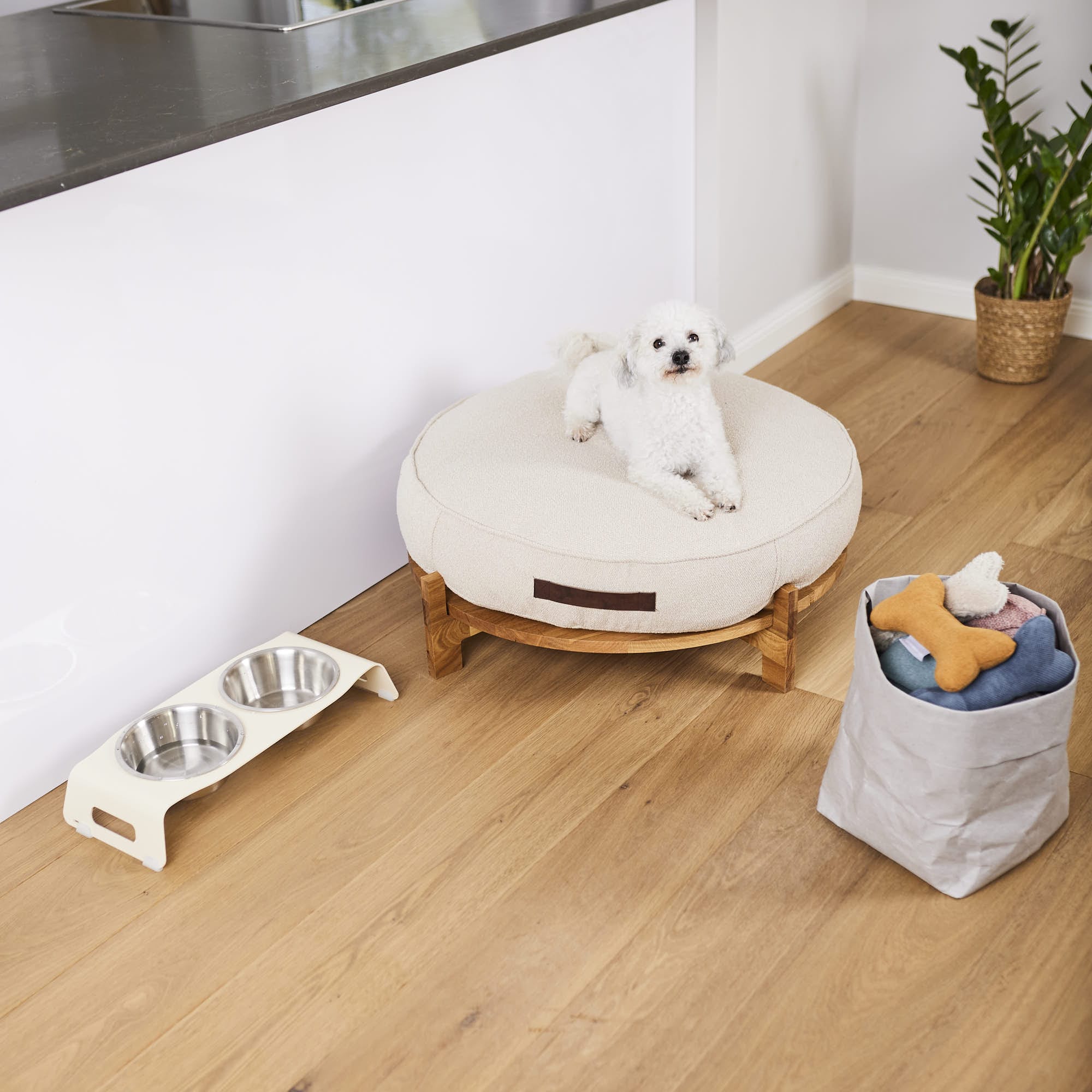 Orthopädisches Hundekissen in beige daneben Stahl Hundenäpfe und Hundespielzeug
